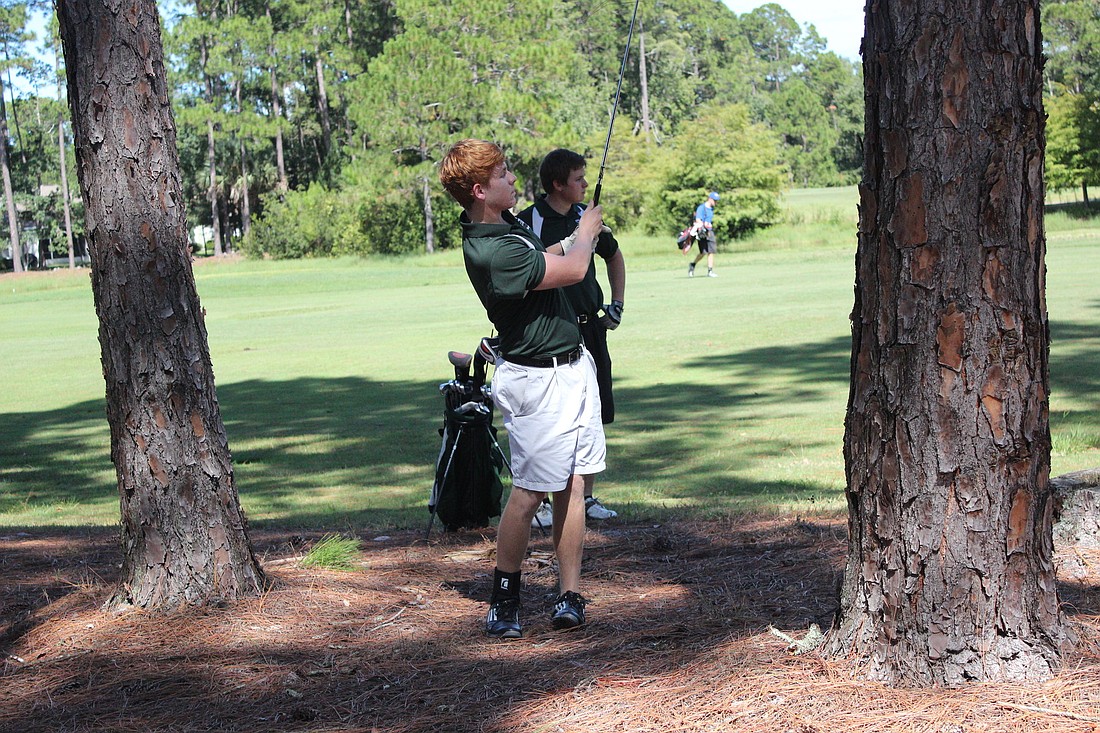 Barret Manfre shoots a ball out of the woods.