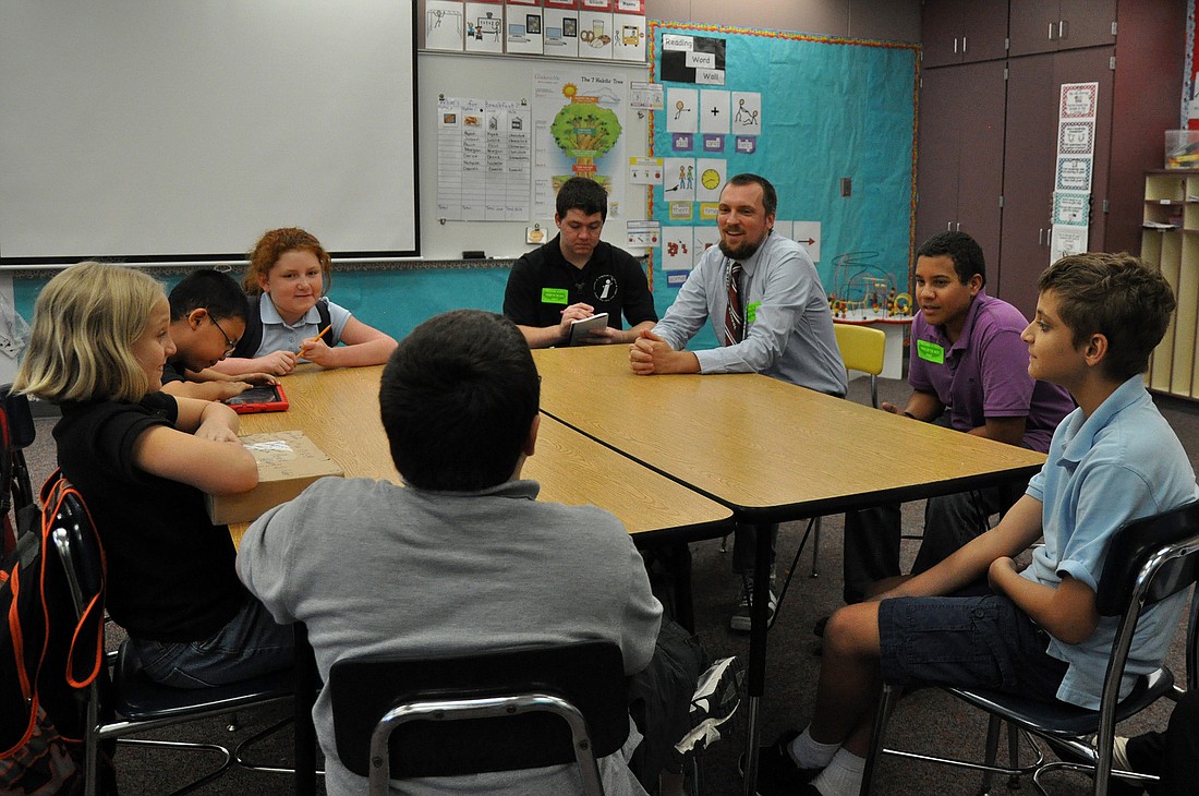 Teacher Blake VandeBunte joins journalism students Raphael Santiago and William Naughton as they interview students in the Josh Crews Writing Project.