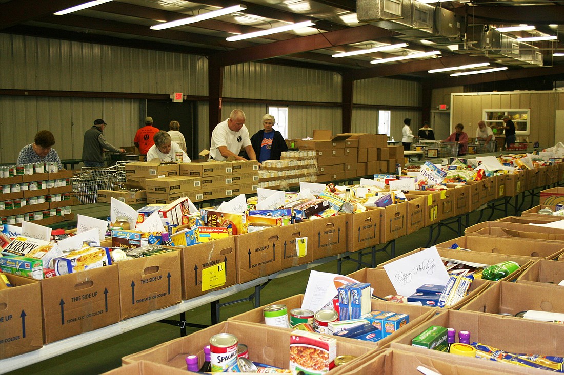 Volunteers fill meal boxes at the Flagler County CattlemanÃ¢â‚¬â„¢s Hall in 2012. (Courtesy photo.)
