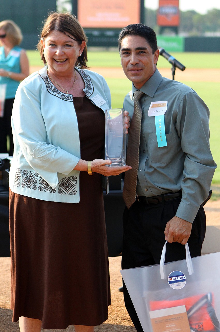 Virginia Haley presents Sal Picerno, of TooJay's Restaurant, with the award for Guest Service Excellence - Front Line Dining at the 2011 National Tourism Week Awards ceremony Thursday, May 12, at Ed Smith Stadium.