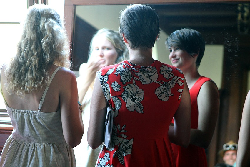 Kaitlin Lovering puts on some lip gloss while Kate Boeyen also looks in the large mirror inside College Hall prior to New College's 2011 Commencement ceremony Friday, May 20 at College Hall Bay Front.