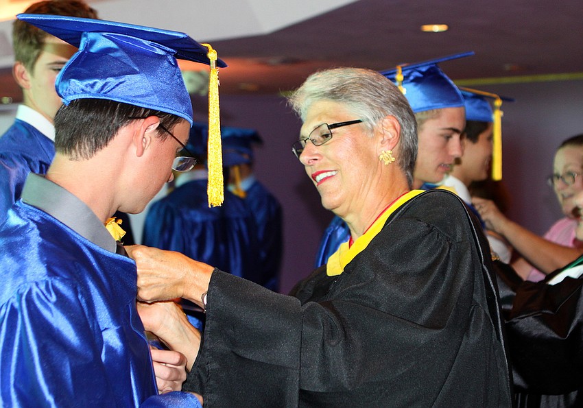 Jacob Sumrow has his yellow flower pinned on by Martha Ackroyd, the AP/Honors Biology teacher, prior to graduation from Pineview High School Sunday, June 5 at Van Wezel.