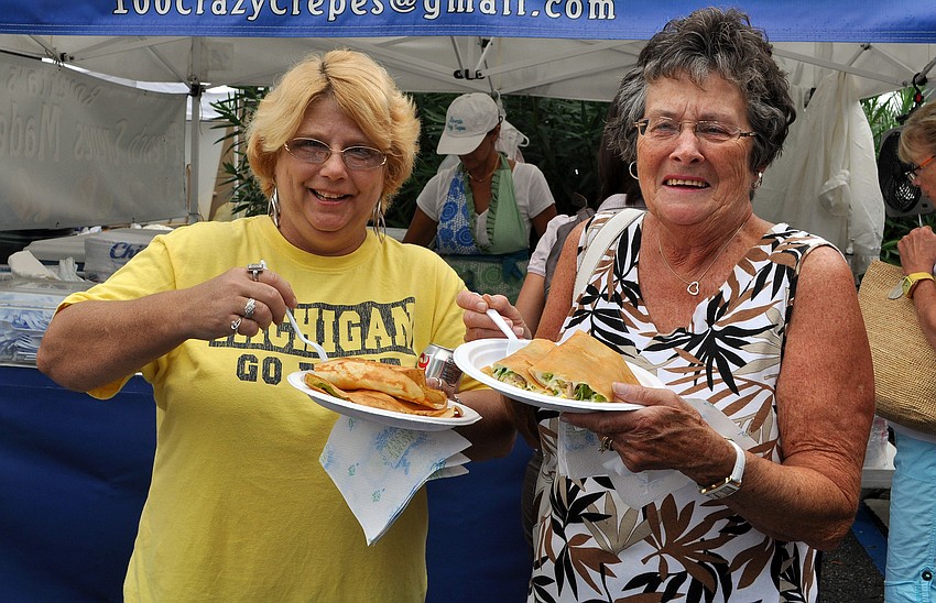 Wendy Lelli and Shirley Wilson enjoy some seafood crepes from Roverta's at the Sarasota Farmers Market first ever Shrimp and Lobster Festival.