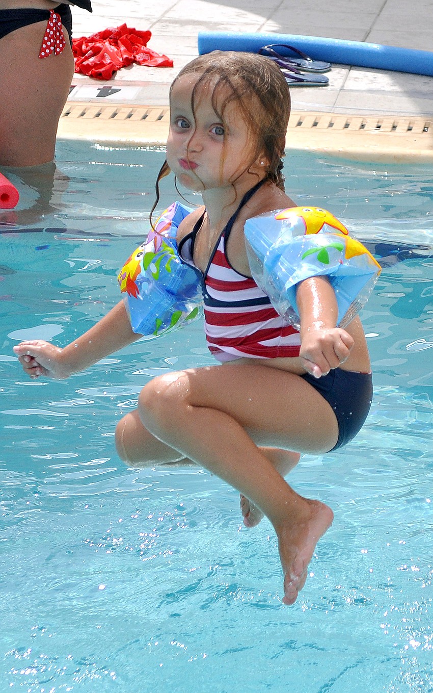 Naomi Cassagnol, 4, hangs above the water before splashing into the pool Monday, July 4 at Sarasota Yacht Club.