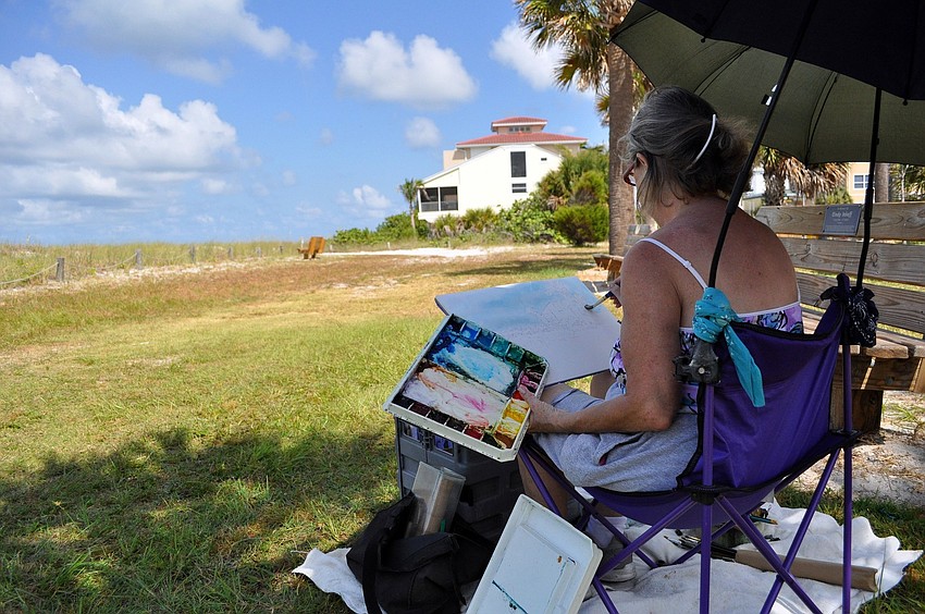 Marilyn Offer paints in the palm trees on her canvas Wednesday, June 22 out in the grass by Siesta Key Public Beach. Offer says that Siesta is her favorite place to paint.