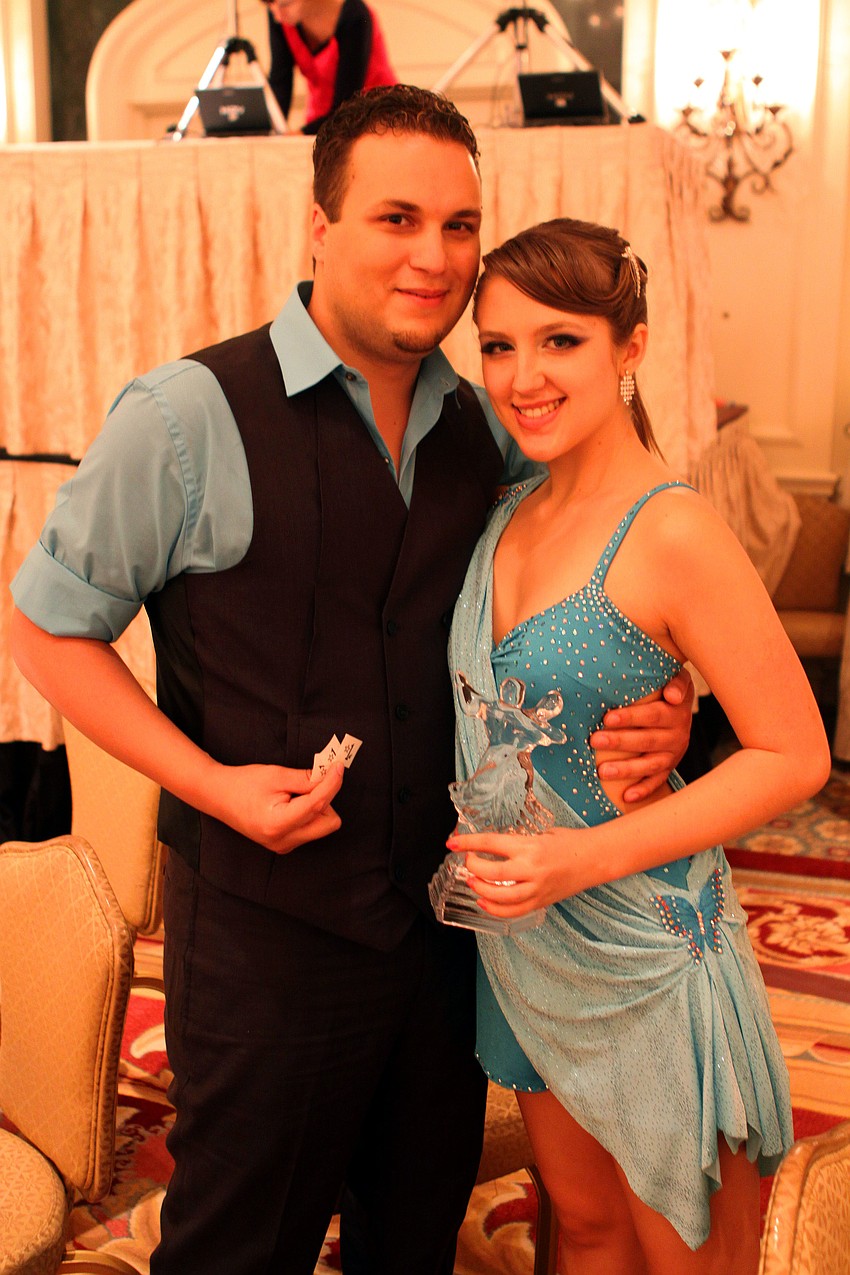 Corey McCance and Laura Williams pose with their participation statue and their award papers.