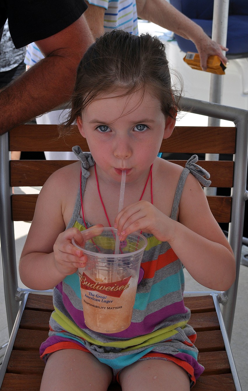 Gracie Lane, 3, enjoys a cranberry and orange juice smoothie in the shade.
