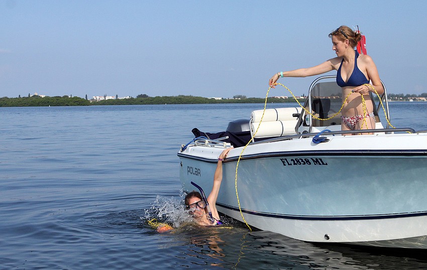 Samantha Jones jumps into the water as her sister, Anna, hands off the rope and buoy Saturday, August 13 during the 4th Annual Sarasota Bay Great Scallop Search.