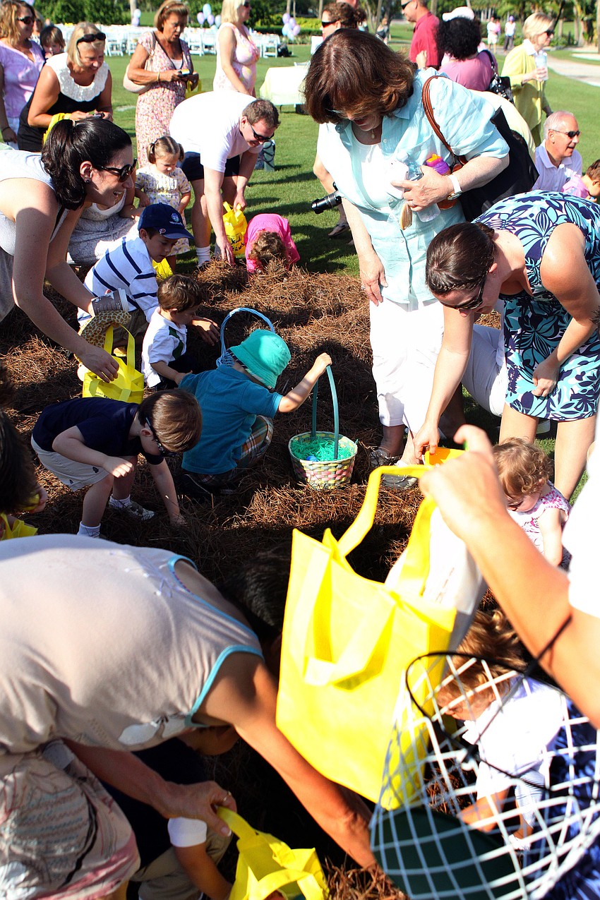 Parents try to help their kids find as many Easter eggs as possible Sunday, April 24 at the Longboat Key Club's Annual Easter egg hunt.