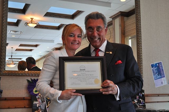 Sandra Rios accepts an award on behalf of the Longboat Key Club and Resort from St. Armands Circle Association President Andrew Vac.