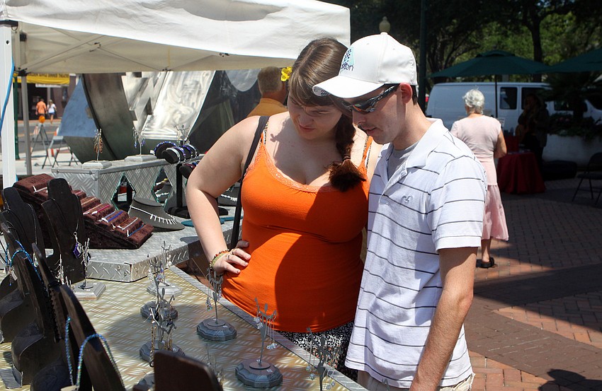 Cassidy Stoner and Bradley Dever look at some jewelry at the Craft Festival Sunday, May 22 along Main Street and in Five Points Park.