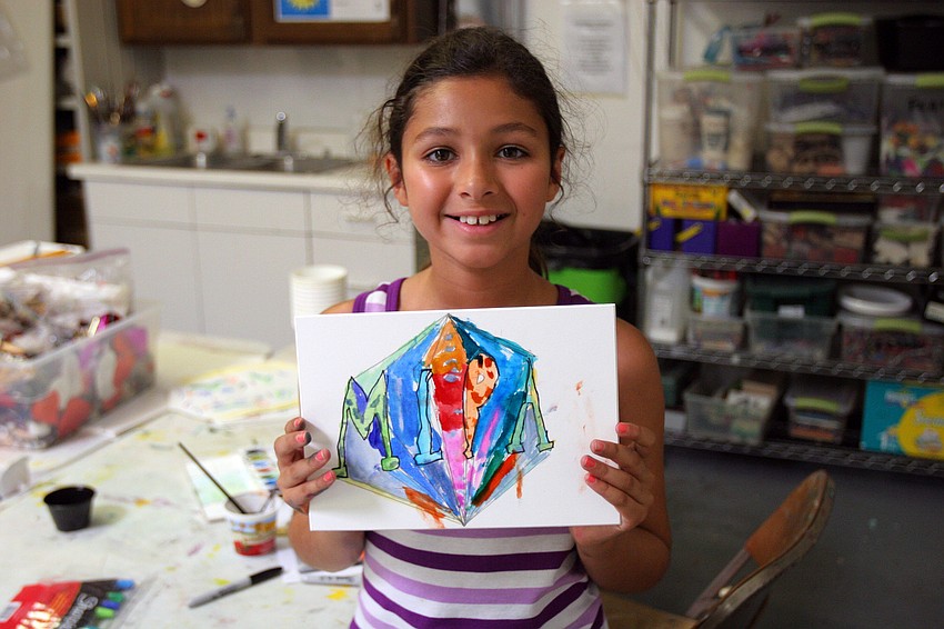 Mira Kumar, 8, shows of her name spelled out in Greek letters Tuesday, June 14 during her It's All Greek To Me! summer art class at Art Center Sarasota.