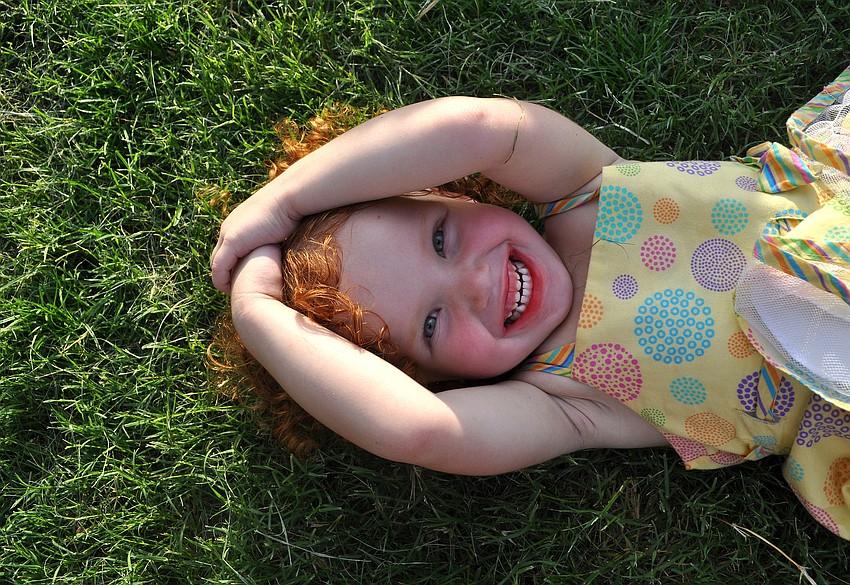 Kelsey Greuter, 2, enjoys resting in the grass.