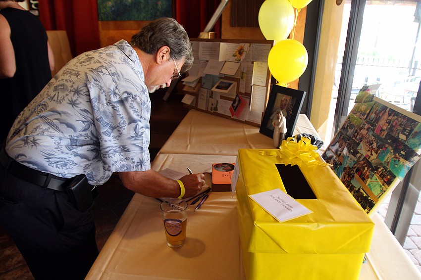 Jeff Orenstein writes the couple a nice note in the guest book that was on one of the display tables Saturday, Aug. 28 at Claytonâ€™s Siesta Grille.