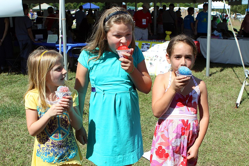 Julia Andrew, 6, Fiona Coffey, 9, and Myah Mattison, 6, enjoy their snow cones on Saturday, March 19 at the Sarasota Springfest out at Palmer Ranch.