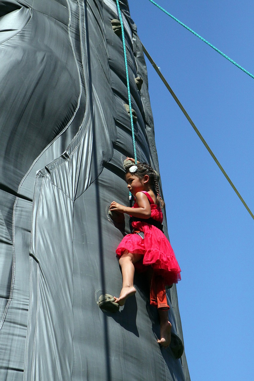 Gracie Chung, 5, climbs the inflatible rock wall on Sunday, March 20 at Temple Emanu-El's Purim Carnival.