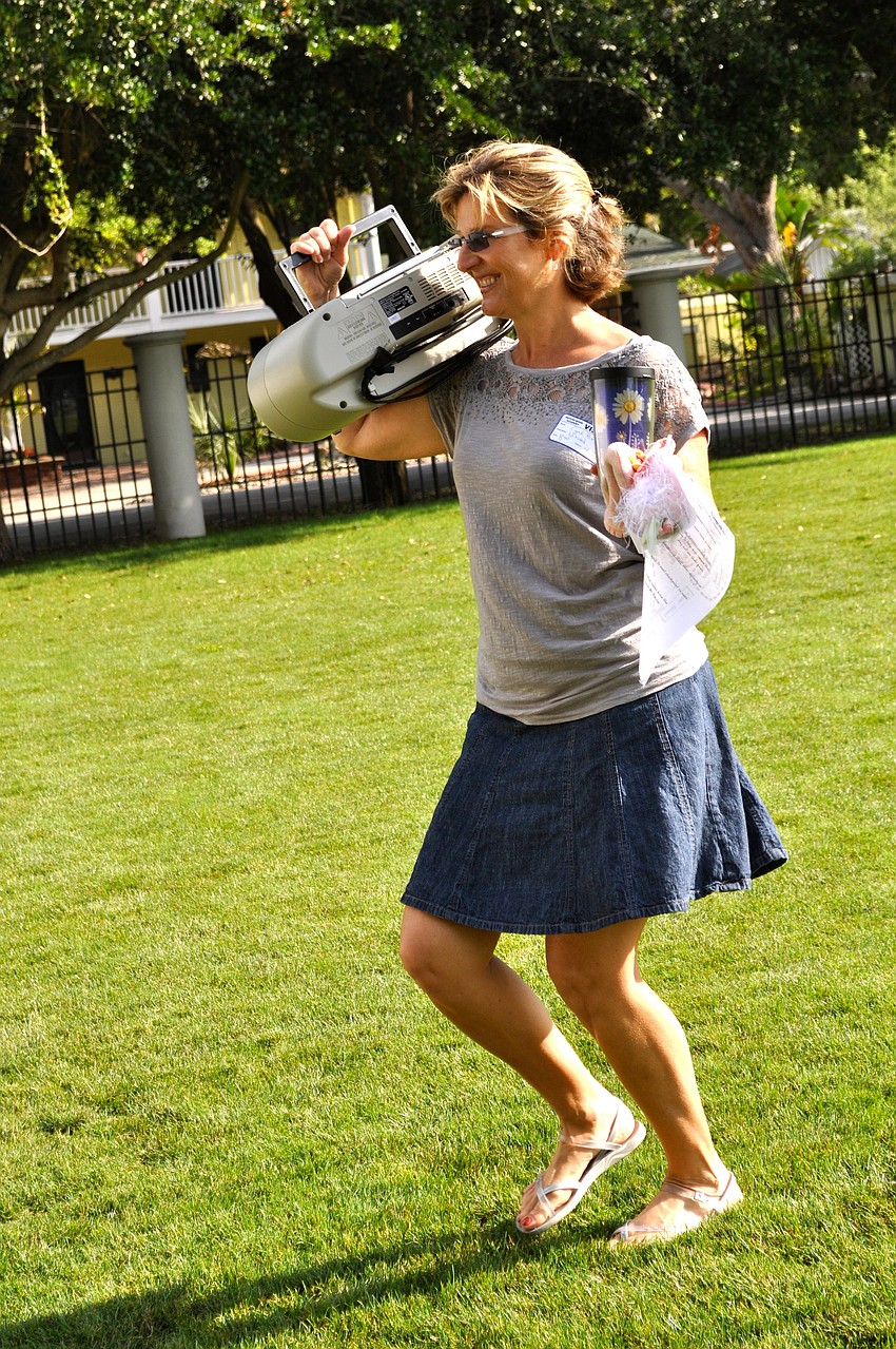 Cyndi Paxton be-bops around with a boom box on her shoulder that's playing 