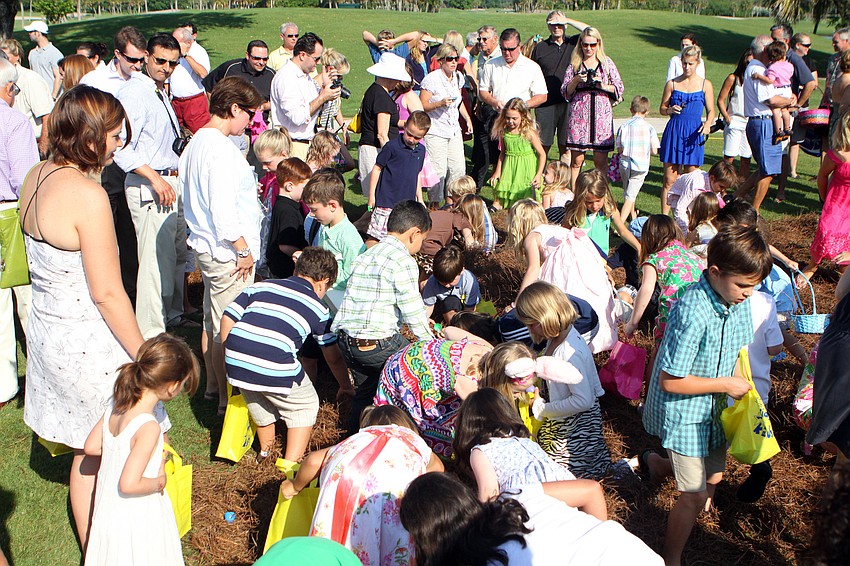 Kids scramble to find as many eggs as possible as their parents encourage them Sunday, April 24 at Longboat Key Club's Easter egg hunt.