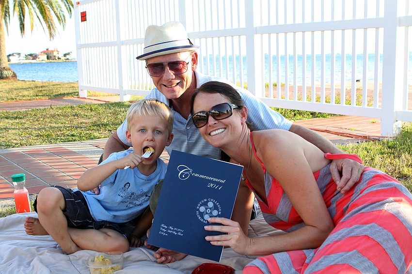 Breyten Vanderberg, 4, enjoys his macaroni and cheese while sitting with Bernard Vroom and Nicole Vanderberg, a staff member at New College, during New College's 2011 Commencement ceremony Friday, May 20 at College Hall Bay Front.