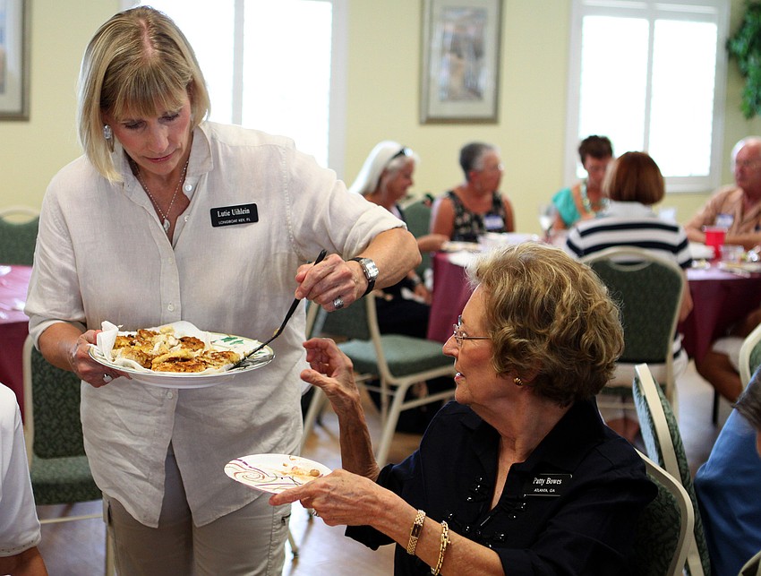 Lutie Uihlein serves Patty Bowes some more fish Saturday, July 16 at the Christ Church and Spanish Main fish fry.