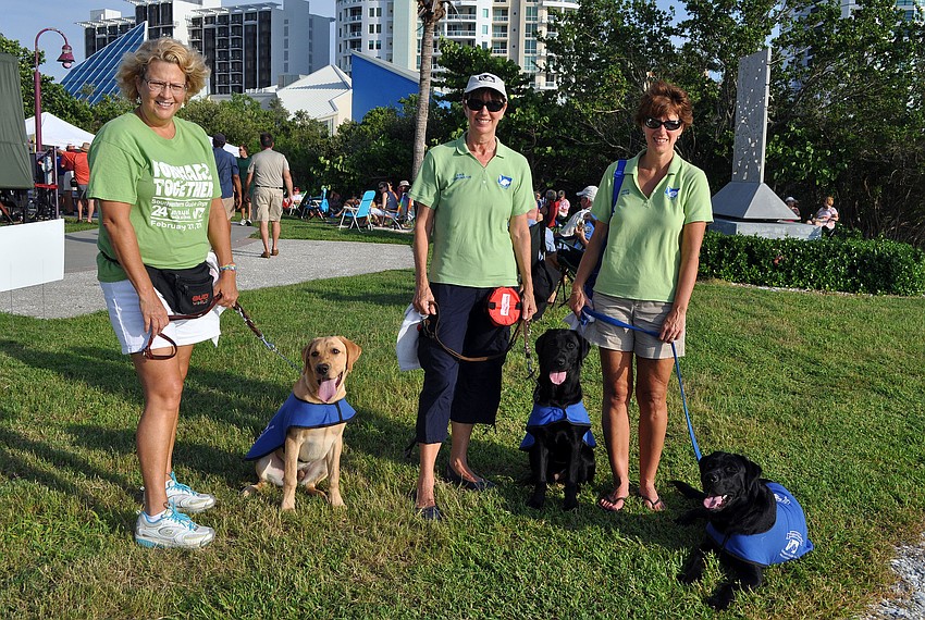 Susan LeBourgeois and Trey, Fran Kramed and JP, and Sue Tomasso and Frela of the Bradenton Puppy Raising Group for South East Guide Dogs pose together Friday, August 12 during Friday Fest at the Van Wezel.