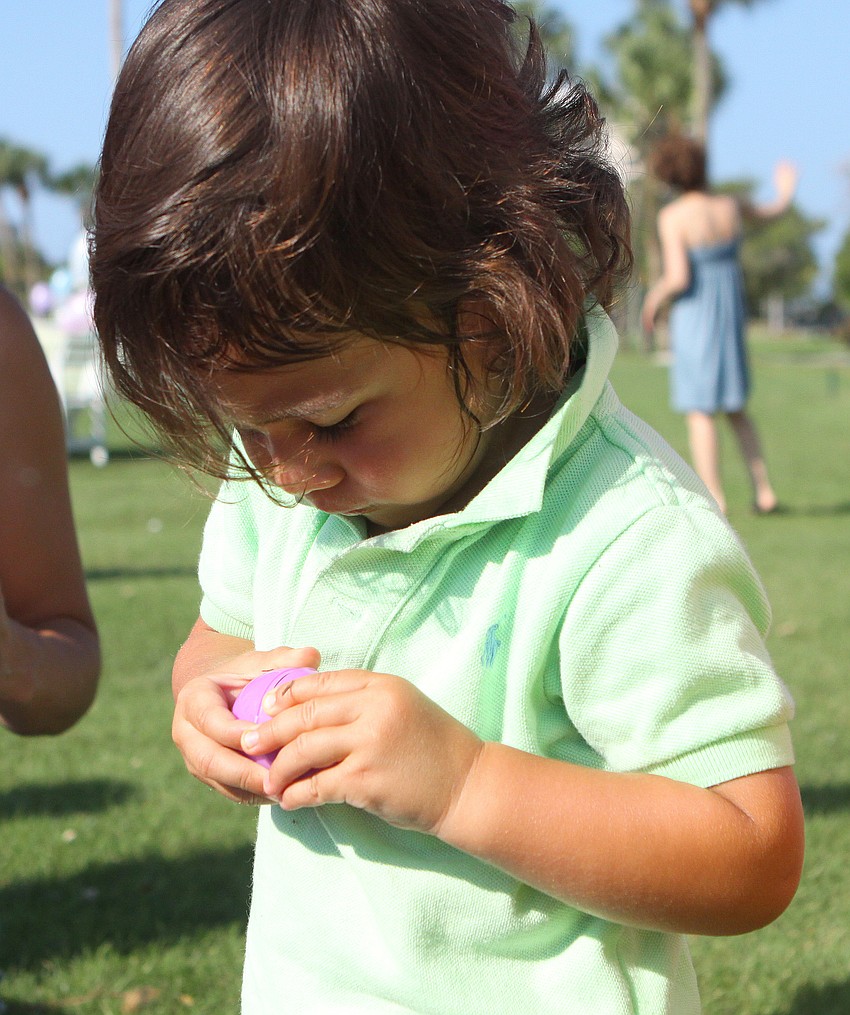 Charlie Rasool, 2 1/2, opens up one of his many Easter eggs Sunday, April 24 at Longboat Key Club's Easter egg hunt.