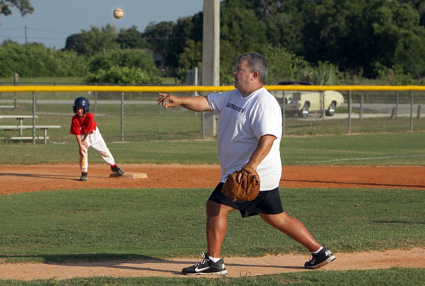 Coach Tim Enos pitches to one of his players Monday, May 9 out at Twin Lakes Park.