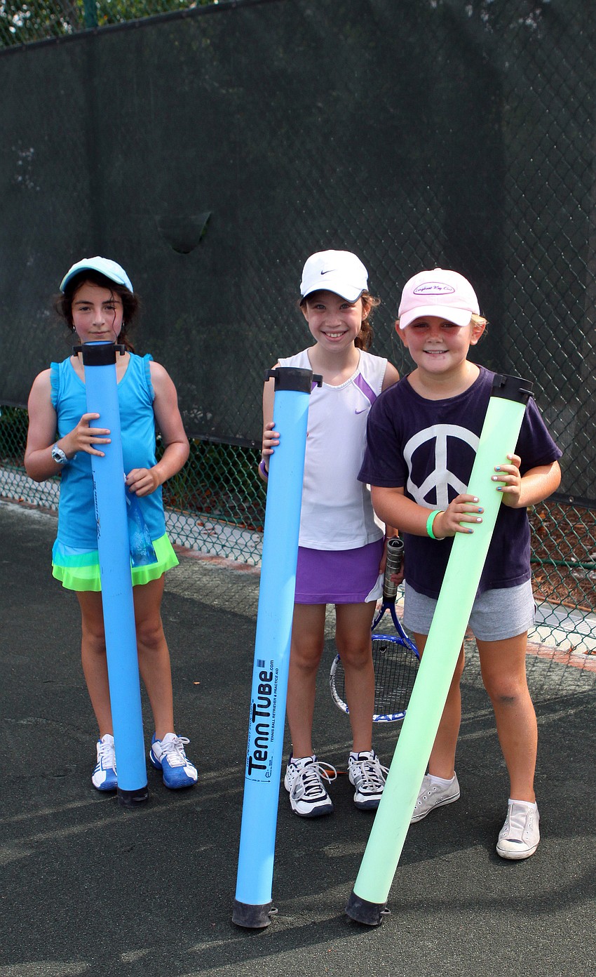 Lennon Issac, 10, Dara Grocer, 9, and Averie Robinson, 9, pick up balls with some TennTubes during Longboat Key Club's Tennis Camp Monday, June 6 at Longboat Key Club's Tennis Gardens.