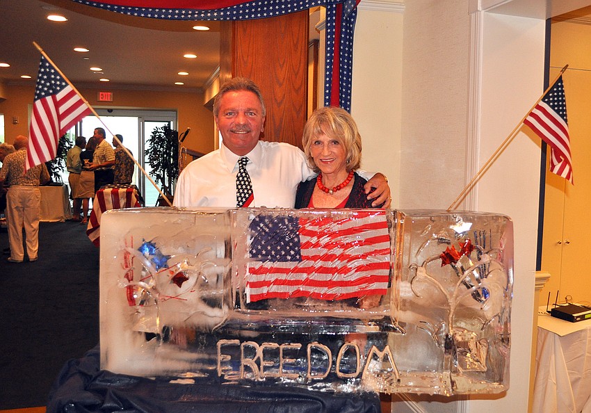 Rob Edwards and Karel Beck pose with the ice sculpture created by Dave Andrews Monday, July 4 at Bird Key Yacht Club.