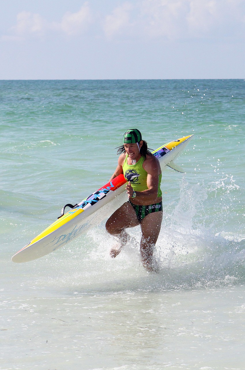 Sarasota County lifeguard Robert Martini runs hard through the water with his colorful board during the rescue board race.
