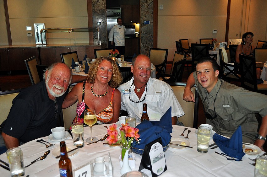 Rick and Linda Mariz pose with Larry Beggs and Tyler Kelley at their table Saturday, August 6 during Scallopalooza at the Sarasota Yacht Club.