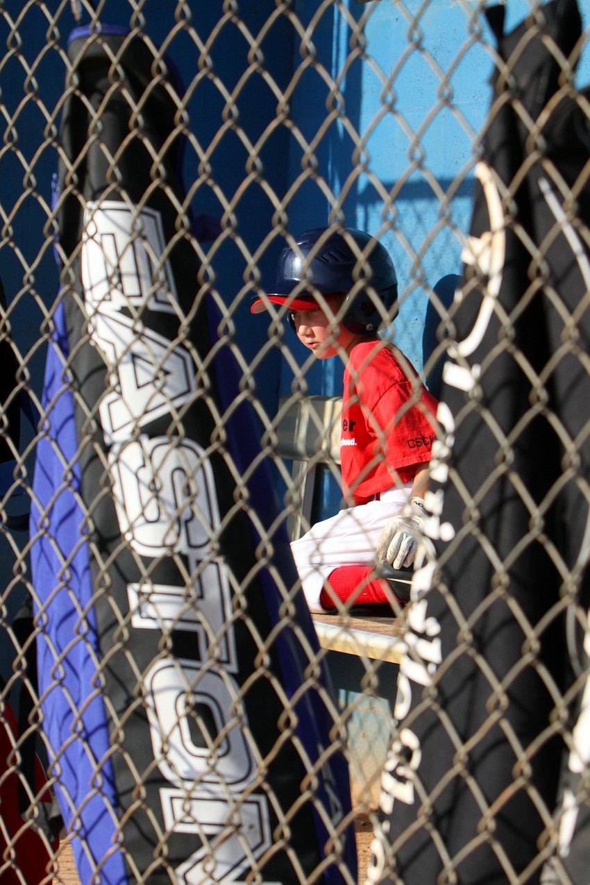 Hunter Jones, 8, sits out for an inning and watches his fellow Observer team mates during their final game of the Spring season Monday, May 9 out at Twin Lakes Park.