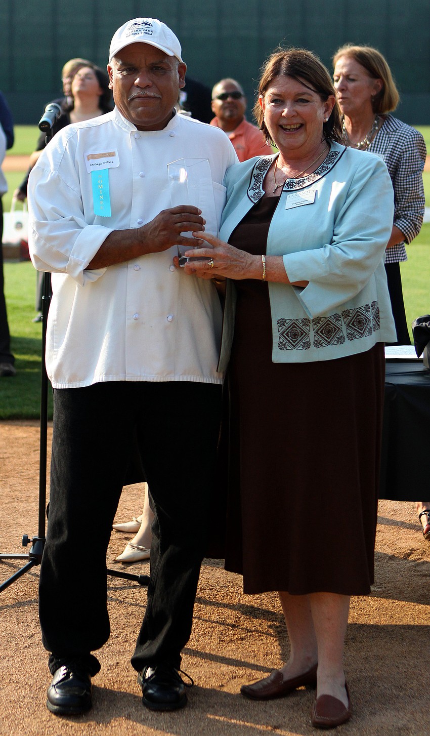 Rufugio Gomez of Marina Jack Restaurant, accepts the award for Guest Service Excellence - Back of the House - Dining from Virginia Haley at the 2011 National Tourism Week Awards ceremony Thursday, May 12, at Ed Smith Stadium.