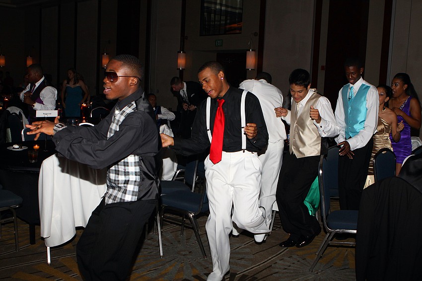 A group of guys dance their way to the dance floor to 