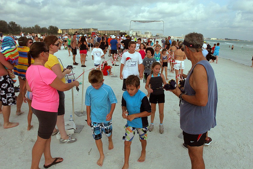 Participants in the 1-mile fun run cross the finish line Tuesday, June 14 on Siesta Key Beach. Each participant got a ribbon and a freeze pop.