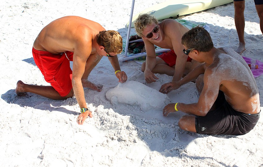 Brevard County lifeguards Robert Lenoci, George Pickett and Jon Ortiz make a race car out of sand during some downtime Thursday, July 14 during the 2011 James 