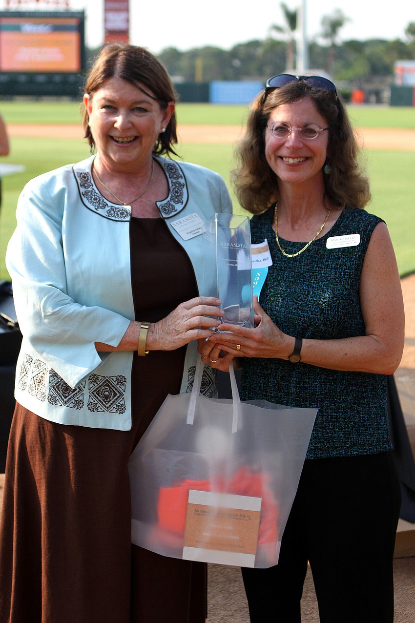 Virginia Haley presents Martha Wells, of Mote Aquarium, with the award for Guest Service Excellence - Management at the 2011 National Tourism Week Awards ceremony Thursday, May 12, at Ed Smith Stadium.