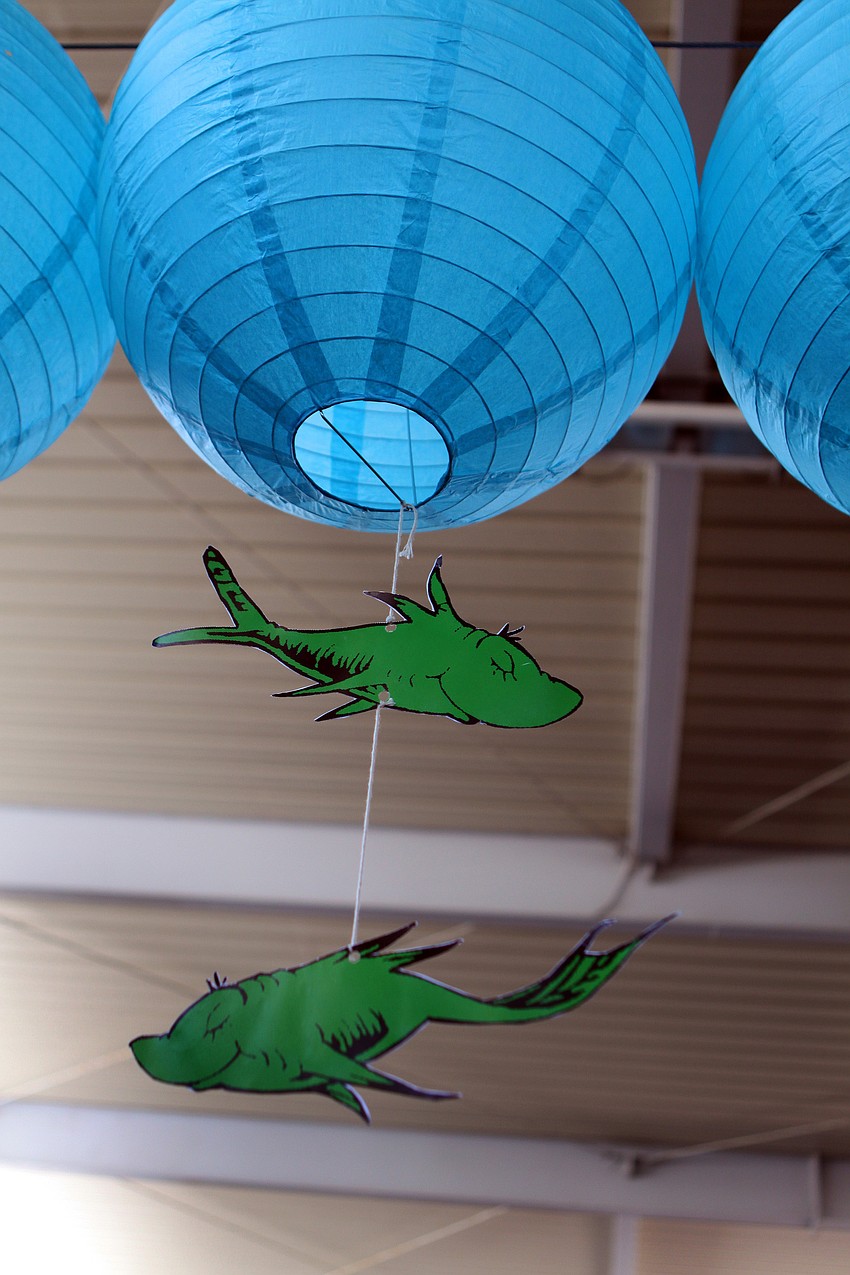 Two green Dr. Seuss fish hang from an aqua paper lantern as part of one of the decorations put up for the World Ocean Day Family Festival Sunday, June 5 at Mote Aquarium.