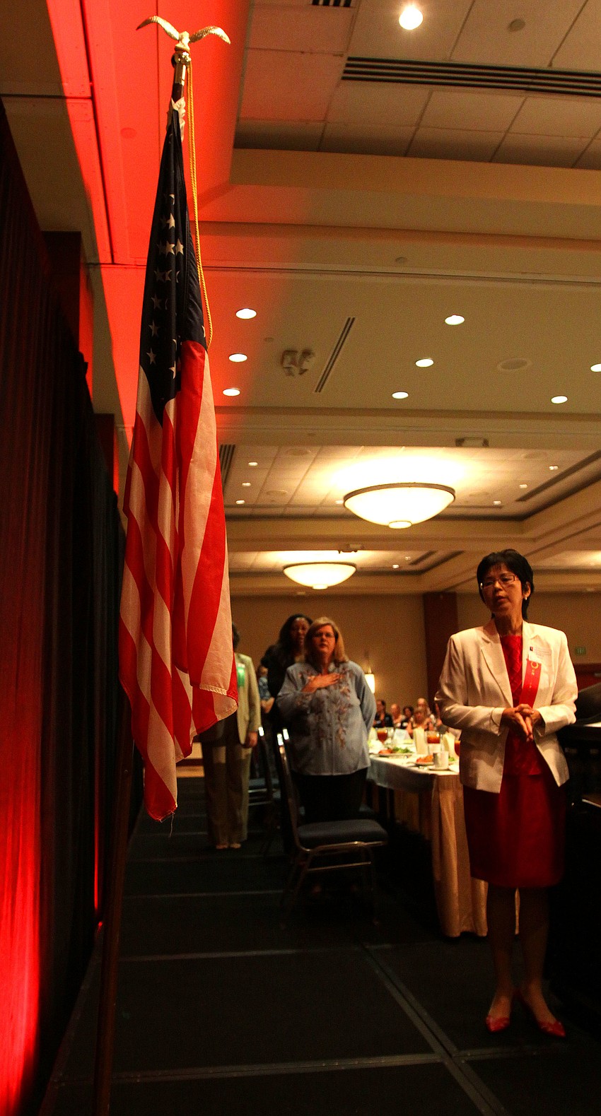 Members of the head table and the rest of the crowd faced the flag and recited â€œThe Pledge of Allegianceâ€.