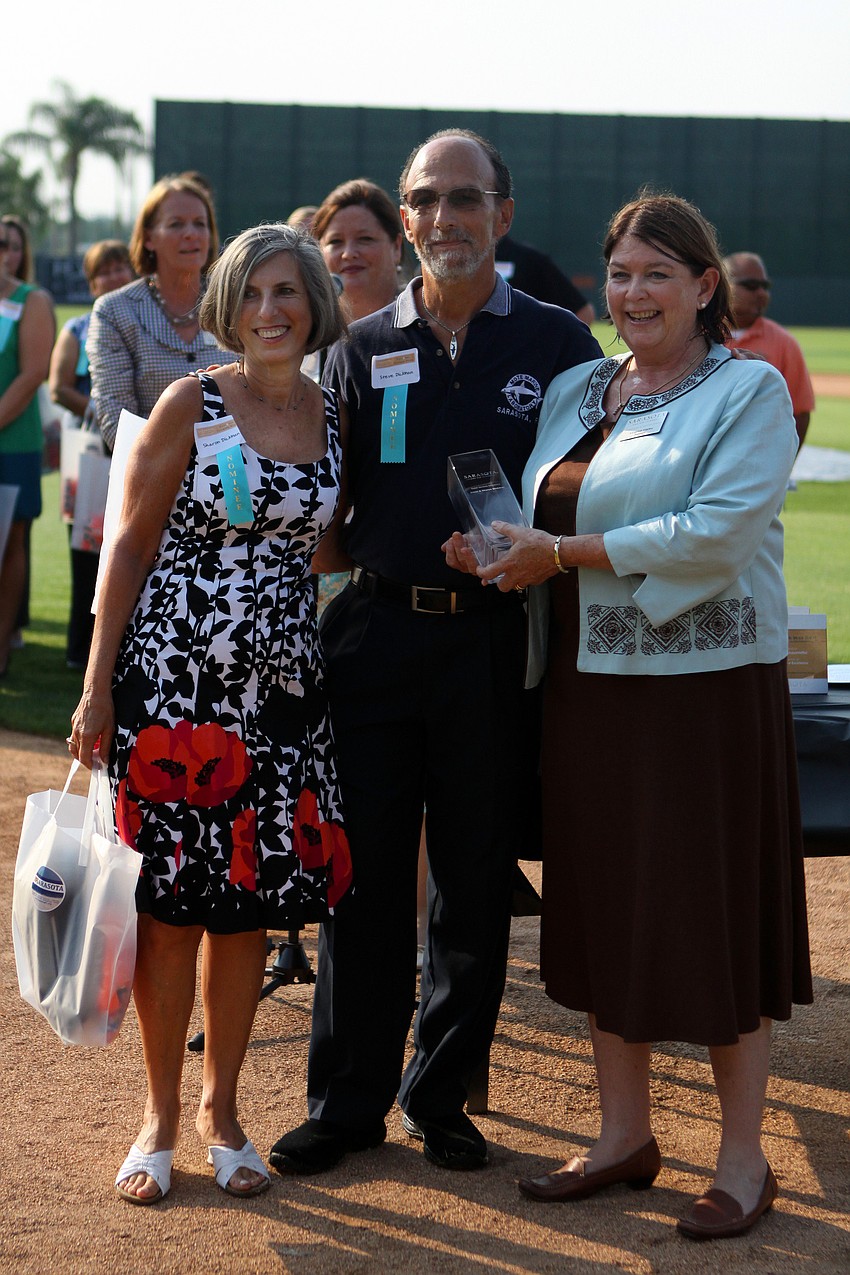 Sharon and Steve Dickman, of Mote Aquarium, accept the award for Guest Service Excellence - Volunteer from Virginia Haley at the 2011 National Tourism Week Awards ceremony Thursday, May 12, at Ed Smith Stadium.