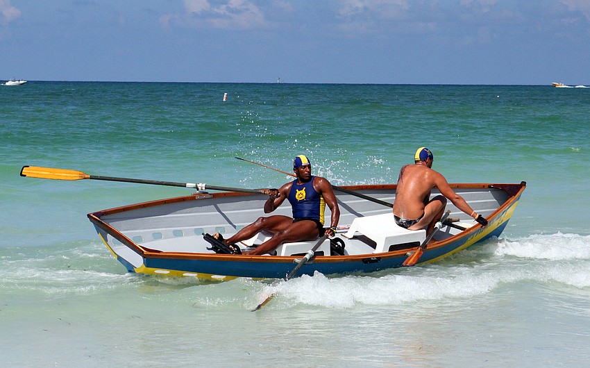Hollywood, FL lifeguard Jose Luis Bolivar tries to keep the boat steady as his partner, Boki Corsovic, gets settled back in the dory during doubles surfboat competition.