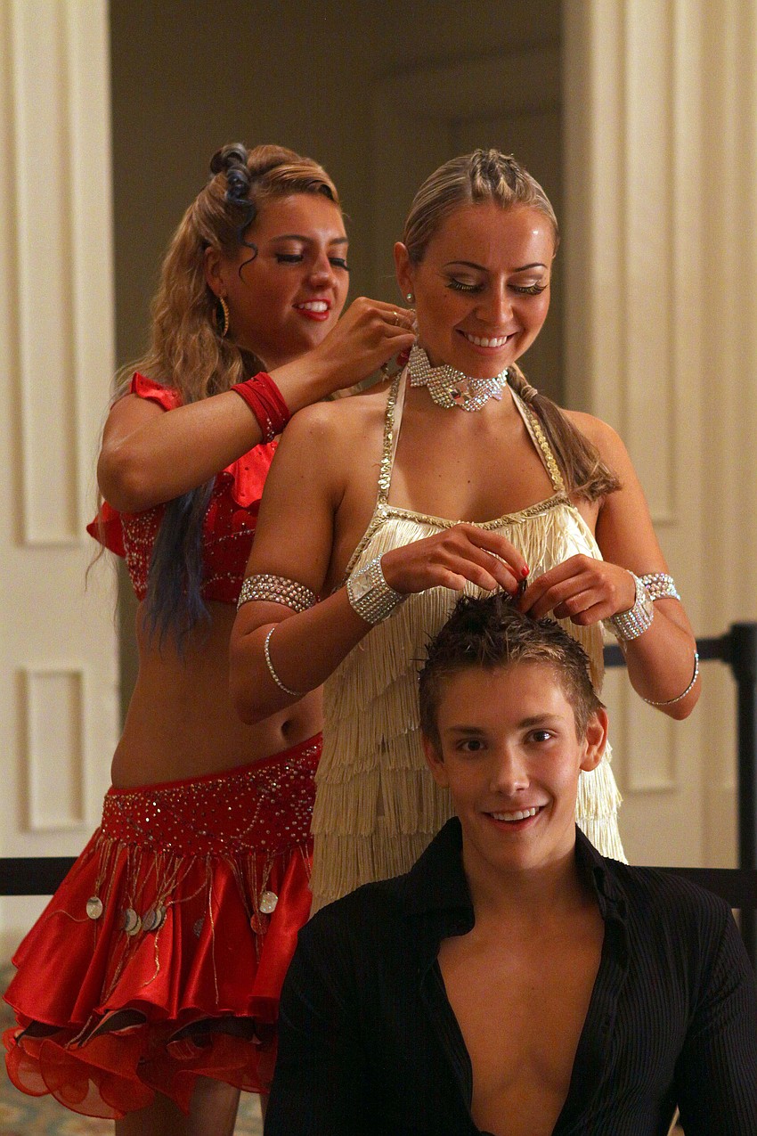 Brittony Swalm, Sofia Sokolenko and Kelton Johnson help one another get ready to go out on the dance floor Wednesday, August 3 during the Florida State DanceSport Championships at the Ritz Carlton Sarasota.