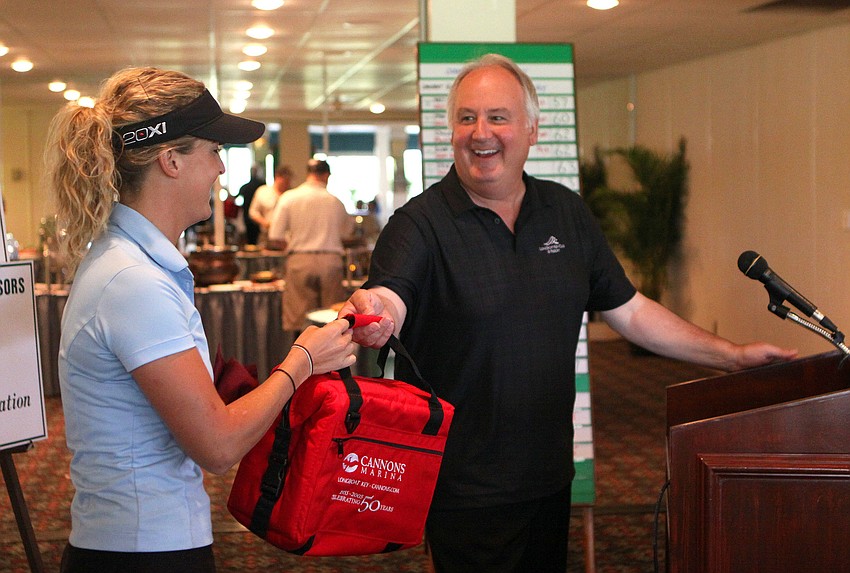 Tom Aposporos hands Kristy Homan her prize for having the longest drive in the 2011 Longboat Key Invitational Friday, May 27 at the Longboat Key Club Islandside.