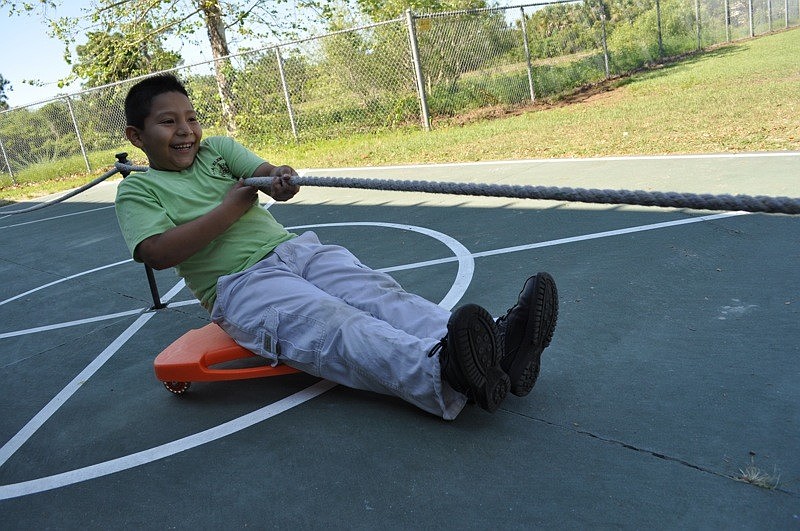 Henry Bojorqez pulls himself along to the next challenge after completing a math problem.