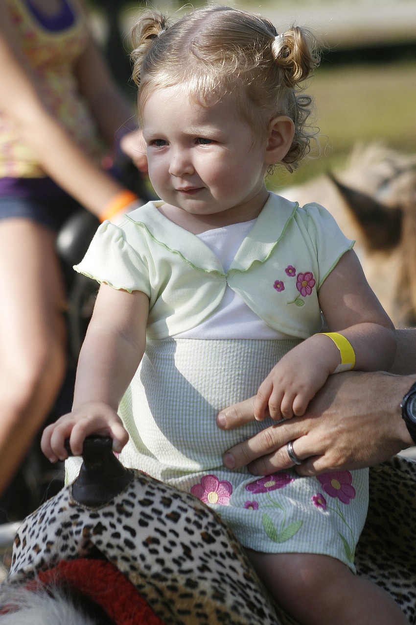 Reagan Vajdik, 18 months, got a little help from her dad during the pony ride.
