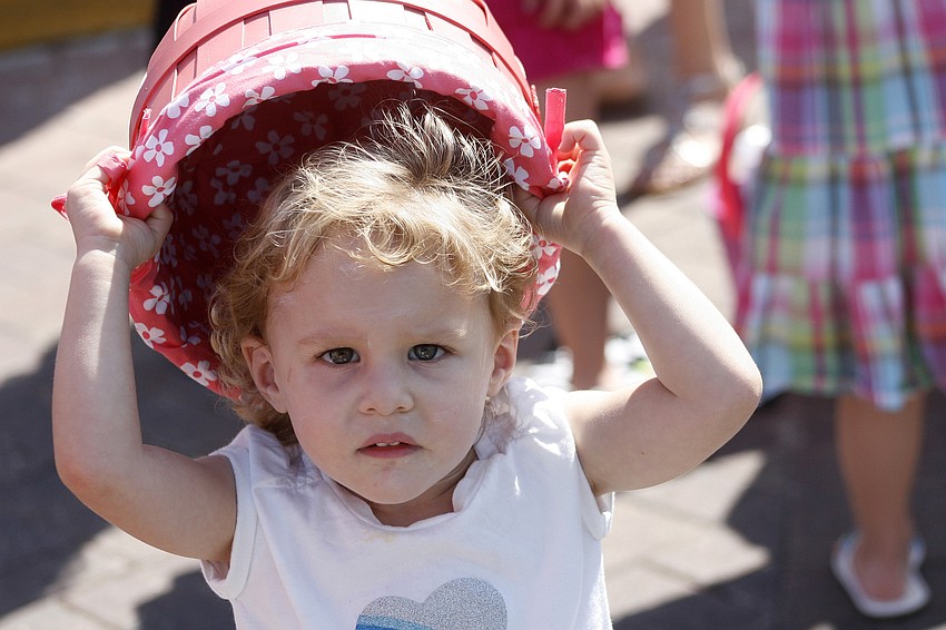 Isabella Lima, 2, thought her basket also made an excellent hat.