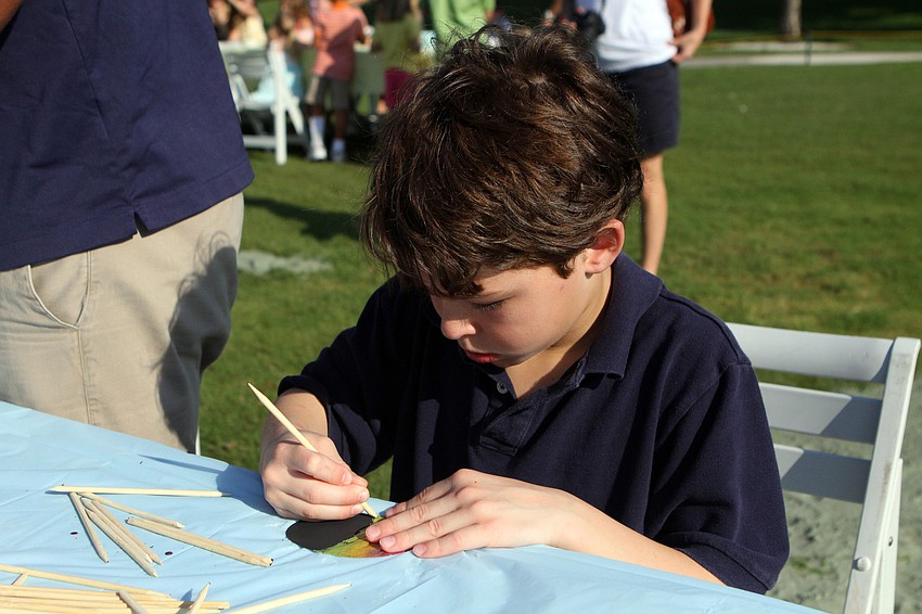 Sean Varwid, 7, scratches in a colorful Easter egg before participating in the Easter egg hunt at Longboat Key Club.