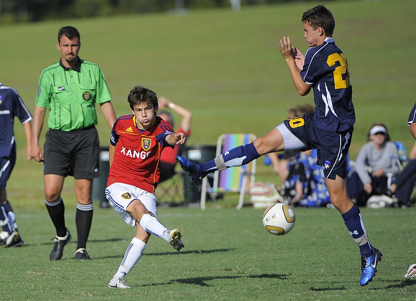 IMG Soccer Academy center back John Taylor blocks a pass by RSL Florida's Rheese Wiltshire.
