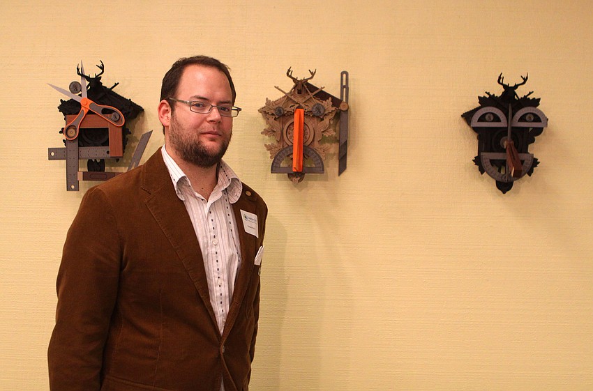 Nathan Skiles poses with some of his art that is featured in his 