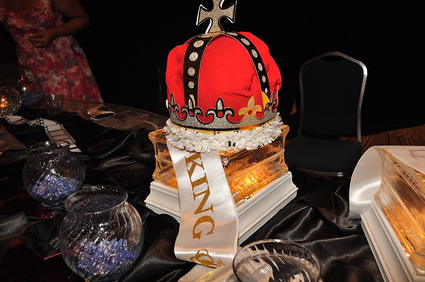 Students cast their votes for prom king and queen next to the king's crown and the queen's tiara.